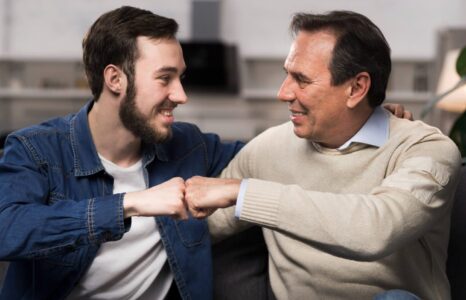 Papá siendo el aval de su hijo. Padre e hijo chocando puños.