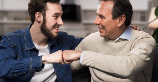 Papá siendo el aval de su hijo. Padre e hijo chocando puños.
