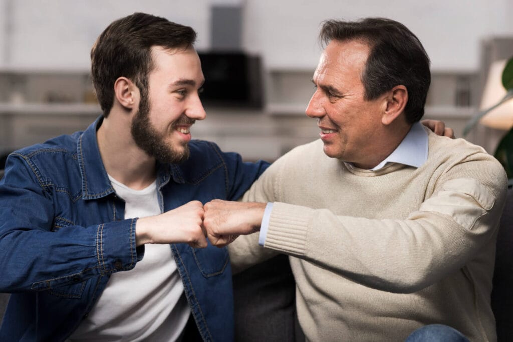 Papá siendo el aval de su hijo. Padre e hijo chocando puños.